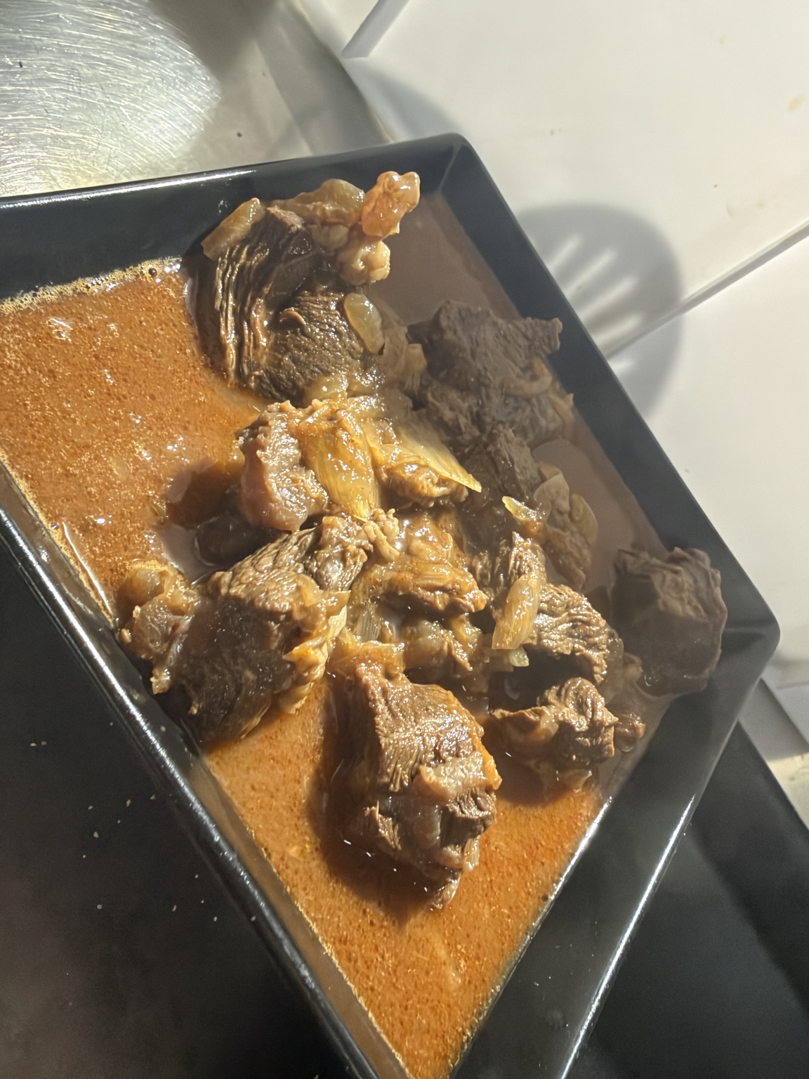 Goulash servito in fondina nera con salsa ricca